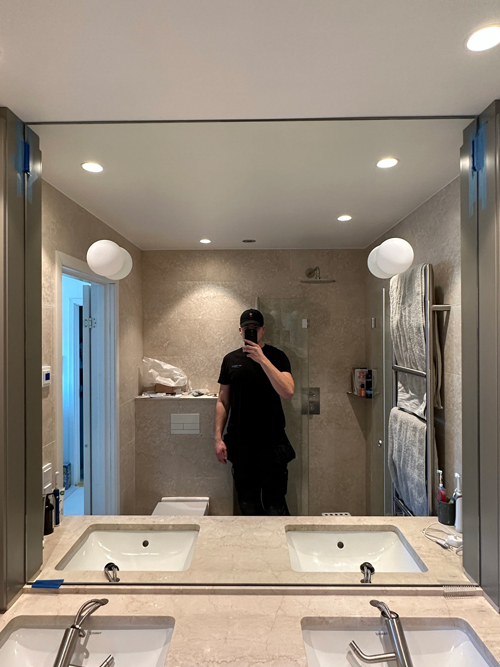 Måttanpassad spegel med håltagning för integrerade lampor.